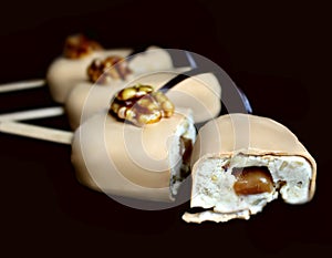 Caramel walnut ice cream gelato popsicle sliced on dark background