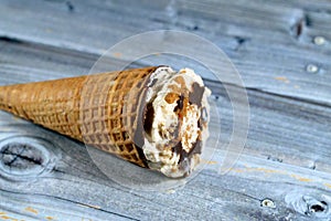 Caramelized biscuit Ice cream of cocoa chocolate and vanilla cone with topping of biscuit pieces and nuts in crispy wafer cones,