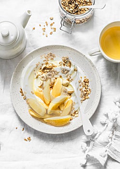 Caramelized quince with Greek yogurt, granola and nuts on a light background, top view. Delicious healthy breakfast, brunch