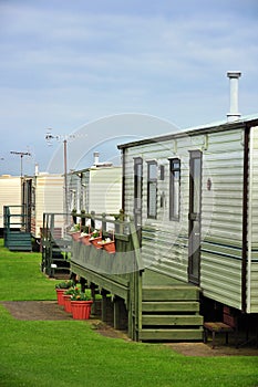 Caravan camp on green grass under clouds