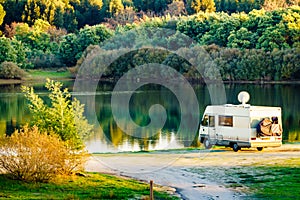 Caravan camping on lake shore with satellite dish on roof