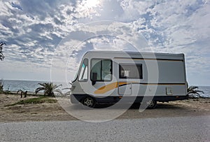 Caravan car by the sea in spring season clouds and sun in the sky