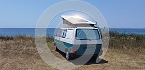 Caravan car solar panels electricity  by the sea in summer beach trees blue sky  travel