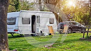 caravan car trailer by the lake grass in spring