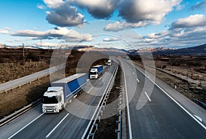 Caravan or convoy of lorry trucks on country highway