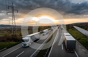 Caravan or convoy of white trucks on highway