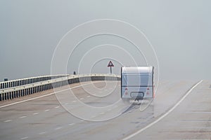 Caravan driving on the motorway in the rain. Motorway in the rain