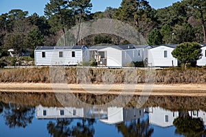 Caravan mobilehome park with modern caravans mobile home prefabricated structure in camping house trailer aside water edge river photo