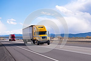 Caravan modern semi trucks on straight highway on plateau