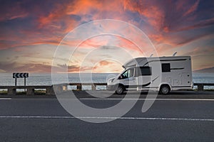 Caravan parked next to the sea at sunset