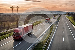 Caravan of Red Lorry trucks on highway