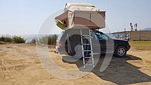 Caravan tent on the top of the car by the beach photo