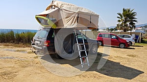 Caravan tent on the top of the car by the beach photo