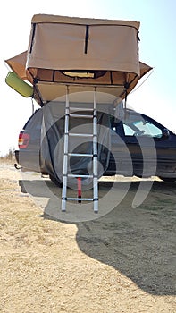 Caravan tent on the top of the car by the beach photo