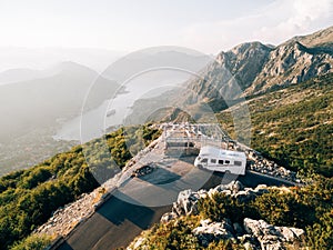 Caravan at the top of Mount Lovchen in Montenegro. A house on wheels near a mountain cliff. Trailer with panoramic views