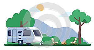 Caravan trailer standing outdoors in woods next to campfire and lounge chairs. Hiking adventure. Automobile camping van