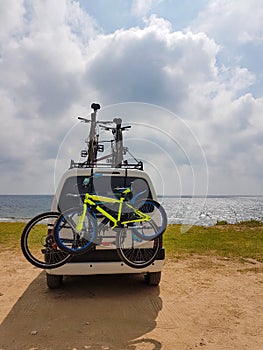 Caravan van beside the sea in cloudy autumn day with bikes on it