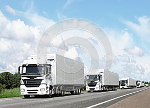 Caravan of white trucks on highway