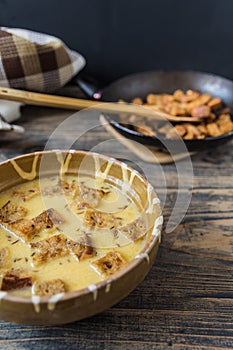 Caraway soup with croutons on rustic wooden table