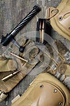 Carbine clip, ammo, gloves and shutter lies on a background.