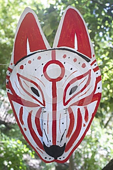 Carboard Kitsune mask hanging on rope
