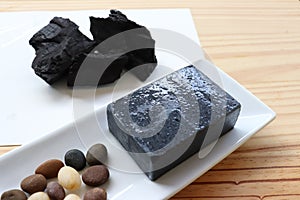 Carbon and bamboo charcoal soap on wood background photo