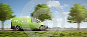 Carbon-neutral delivery with a green van driving on a country road with green trees photo