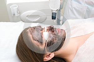 Carbon peeling of the face of a young beautiful woman. Peeling skin renewal. laser point