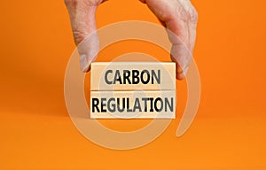 Carbon regulation symbol. Concept words Carbon regulation on wooden blocks on a beautiful orange table orange background.