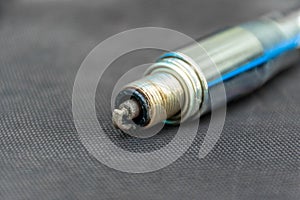 Carbonized spark plug unscrewed and in key, selective focus
