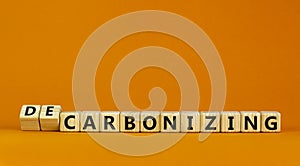 Carbonizing or decarbonizing symbol. Turned wooden cubes and changed words `carbonizing` to `decarbonizing`. Orange background