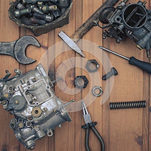 Carburetors for a car engine with tools on wooden table