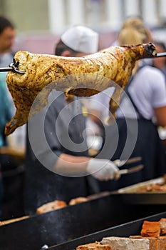 Carcass of sheep, suckling pig on rotating spit with fire on spit, bbq