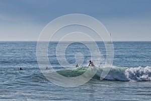 carcavelos beach with surfers and boat