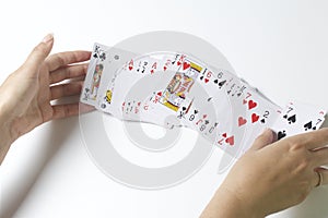 Card game. A woman is shuffling a deck of cards. On a white background.