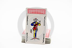 Card joker next to a deck of cards