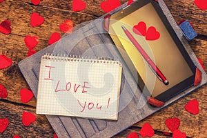 Card with Message Love You. Handwritten text the tablet and pen. Letter Valentine`s Day