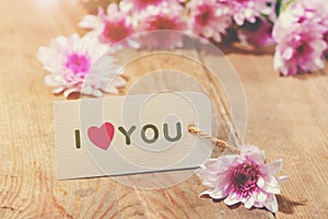 Card with Message Love You on the Letter on wooden background