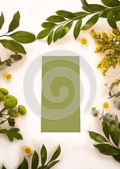 Card mock up on with green plants and flowers. Space for text. Greetings template