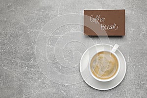 Card with phrase Coffee Break near cup of drink on light grey table, flat lay. Space for text