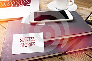 Card saying Success Stories on note pad