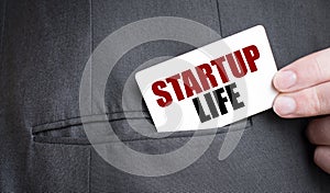 Card with STARTUP LIFE text in pocket of businessman suit. Investment and decisions business concept