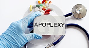 Card with text APOPLEXY supplies, pills and stethoscope. Medical concept photo
