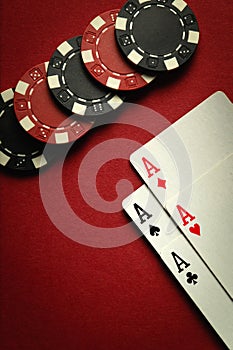 Card winning with a combination of aces four of a kind or quads and chips on a red table in a casino. Place for advertising