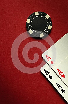 Card winning with a combination of aces four of a kind or quads on a red table in a poker club. Free space for advertising