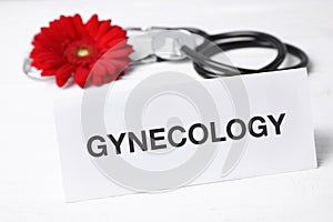 Card with word Gynecology, flower and stethoscope on white background
