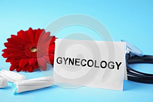 Card with word Gynecology, stethoscope, tampons and flower