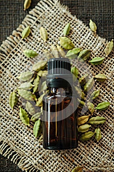 cardamom essential oil on burlap background