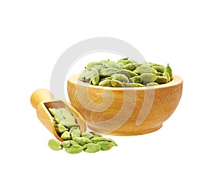 Cardamom pods in wooden scoop and bowl isolated on white background