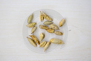 Cardamom seeds isolated on a wooden background. Its scientific name is Elettaria cardamomum. Top view of green cardamom pods photo